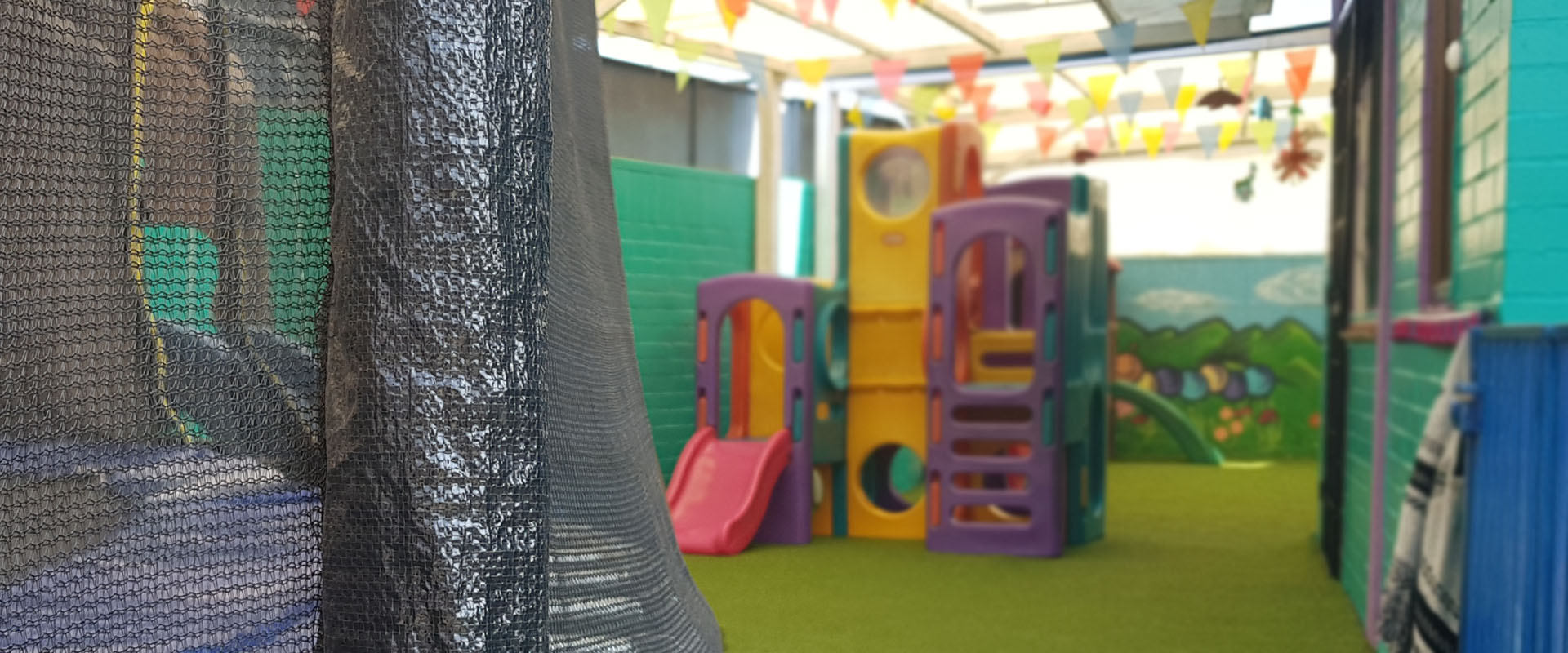 Patio de juegos del Jardín Gusanito con resbalines y juegos de colores
