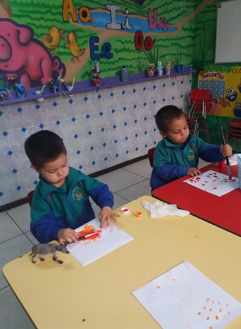 Niños trabajando en sus mesas en la sala