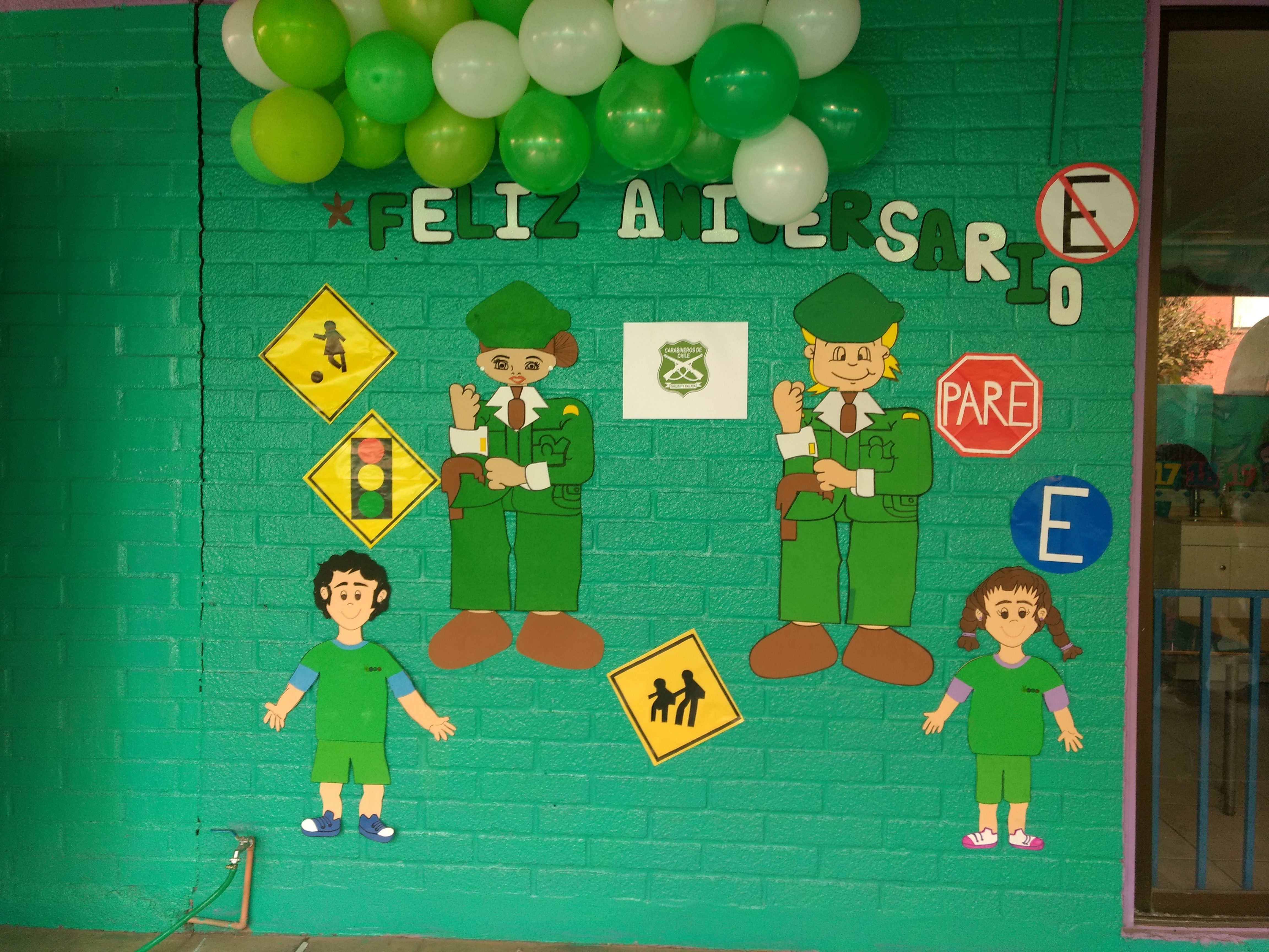 Niños con gorros junto al panel de seguridad vial