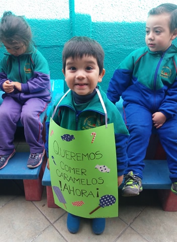 Niño con cartel de bienvenida del jardín