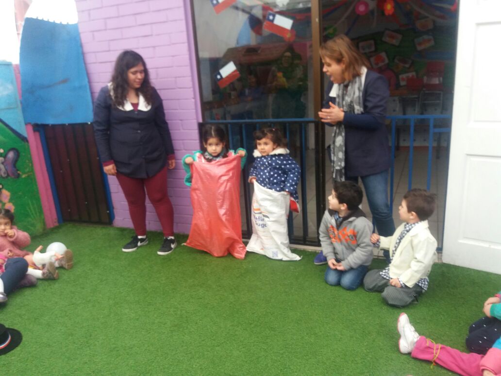 Niñas jugando sobre el pasto del patio